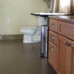 A bathroom with a polished concrete floor.